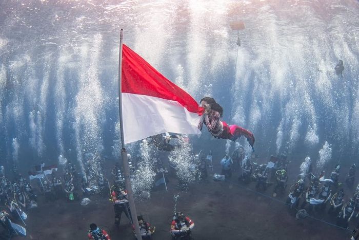 Kenakan Kostum Putri Duyung, Gubernur Maluku Utara Kibarkan Bendera Merah Putih di Bawah Laut