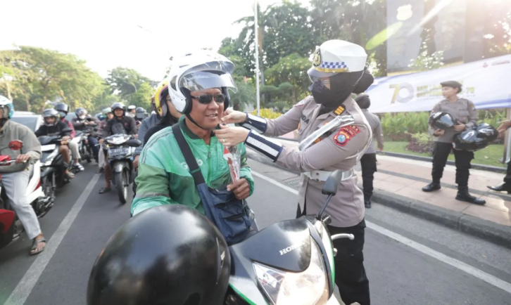 Polwan Polda Jatim Atur Lalin Sambil Bagikan Helm dan Cokelat