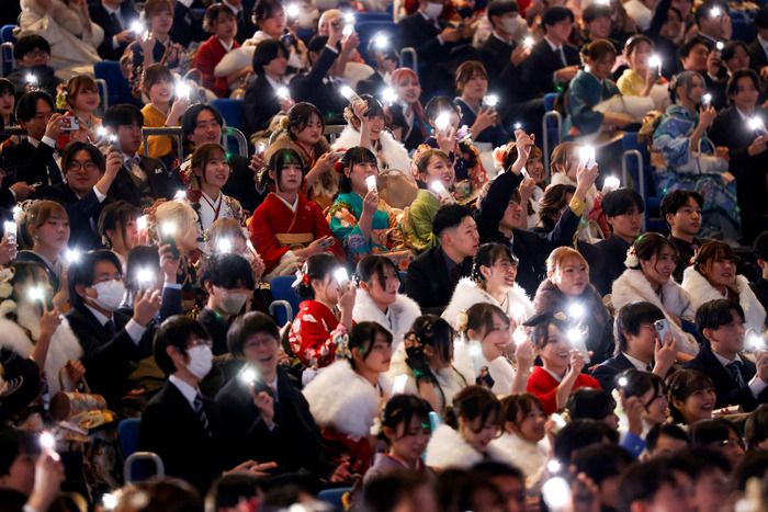 Para peserta menyalakan lampu ponsel pintar mereka selama upacara perayaan Hari Kedewasaan di Yokohama, Jepang, 12 Januari 2026. - Foto oleh REUTERS Manami Yamada