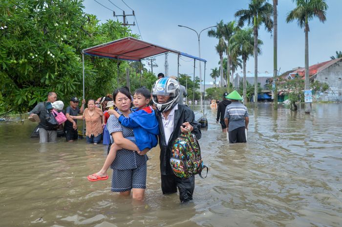 Warga menggendong anaknya saat melintasi jalan yang terendam banjir di Perumahan Duta Bandara Permai, Kosambi, Kabupaten Tangerang, Banten, Senin (12 1 2026). - Foto oleh ANTARA FOTO Putra M. Akbar