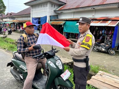 Temui Warga di Pasar Kaiwait Buru Selatan, Polisi Bagikan 100 Bendera Merah Putih