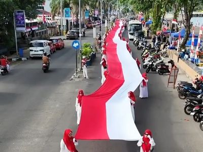 Langkah Penuh Doa, Emak-emak Kirab Bendera Merah Putih Raksasa Sepanjang 180 Meter di Parepare