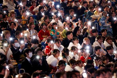 Para peserta menyalakan lampu ponsel pintar mereka selama upacara perayaan Hari Kedewasaan di Yokohama, Jepang, 12 Januari 2026. - Foto oleh REUTERS Manami Yamada