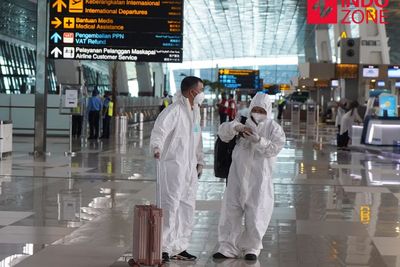 FOTO: Penumpang Pesawat di Bandara Soetta Gunakan Alat Pelindung Diri