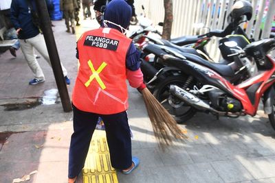 FOTO: Sanksi Sosial Bersihkan Sampah untuk Pelanggar PSBB Jakarta