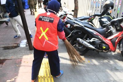 Pelanggar PSBB Disanksi Bersihkan Fasilitas Umum Sambil Pakai Rompi Oranye