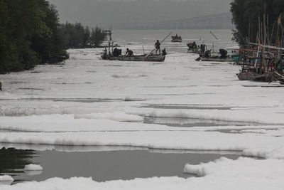 FOTO: Sungai Diselimuti Busa Putih di Surabaya
