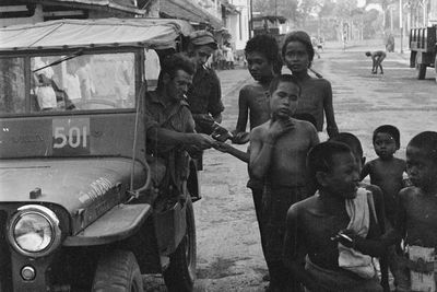 Foto Lawas Anak-anak Antre untuk Dapat Rokok dari Tentara Belanda, Tubuhnya Sangat Kurus