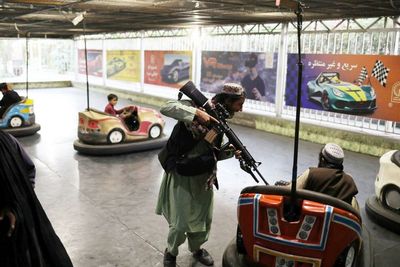 Sambil Tenteng Senjata, Milisi Taliban Asyik Bermain Bom-bom Car Bersama Anak-anak