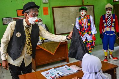 FOTO: Aksi Badut Sosialisasikan Prokes di Sekolah