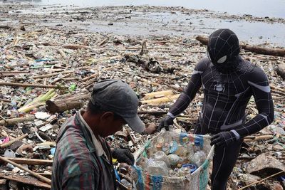 Bikin Heboh! Spiderman Hitam Muncul Kumpulkan Sampah Akibat Banjir Rob