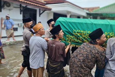 Momen Kapolsek Teluknaga Gotong Keranda Jenazah Satri dan Terjang Banjir