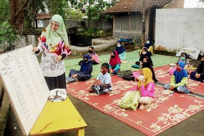 Mahasiswi Cantik Ini Ikhlas Terjang Banjir Demi Mengajar Anak Pesisir