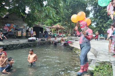 Bikin Heboh! Ada Spiderman Mendongeng di Pinggir Kali Sambil Bagi-bagi Masker