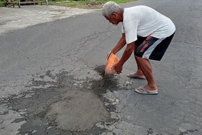 Demi Tabungan Akhirat, Kakek Ini Tambal Jalanan Rusak Pakai Uang Sendiri!