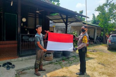 Tak Ada yang Pasang Bendera, Bhabinkamtibmas Tampan Bagikan Merah Putih Gratis