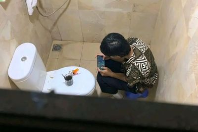Gak Kenal Tempat! Pria Ini Main Mobile Legends di Toilet Lengkap dengan Kopi dan Rokok