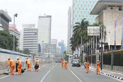 Pasukan Oranye Bersihkan Jalanan Kota Jakarta usai Demo Buruh