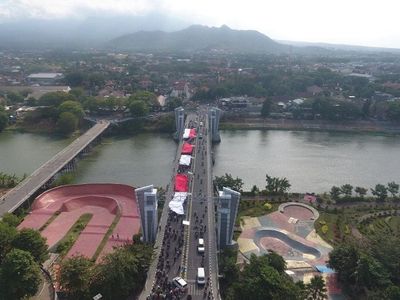 Ratusan Pemuda Kota Kediri Arak Bendera Merah Putih Raksasa untuk Dikibarkan di Atas Gunung